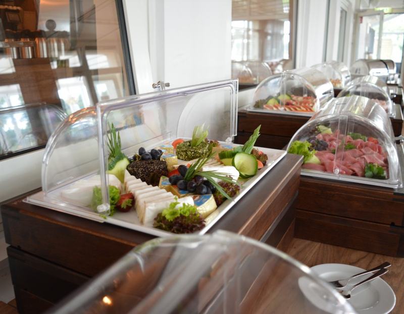 Buffet mit Glashauben und belegten Platten am Fenster zum Kanal